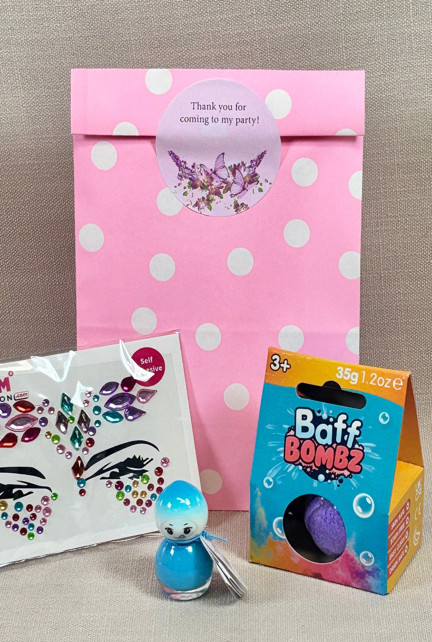 Collection of beauty products including a pink polka dot bag, face gems, nail varnish and a baff bomb.