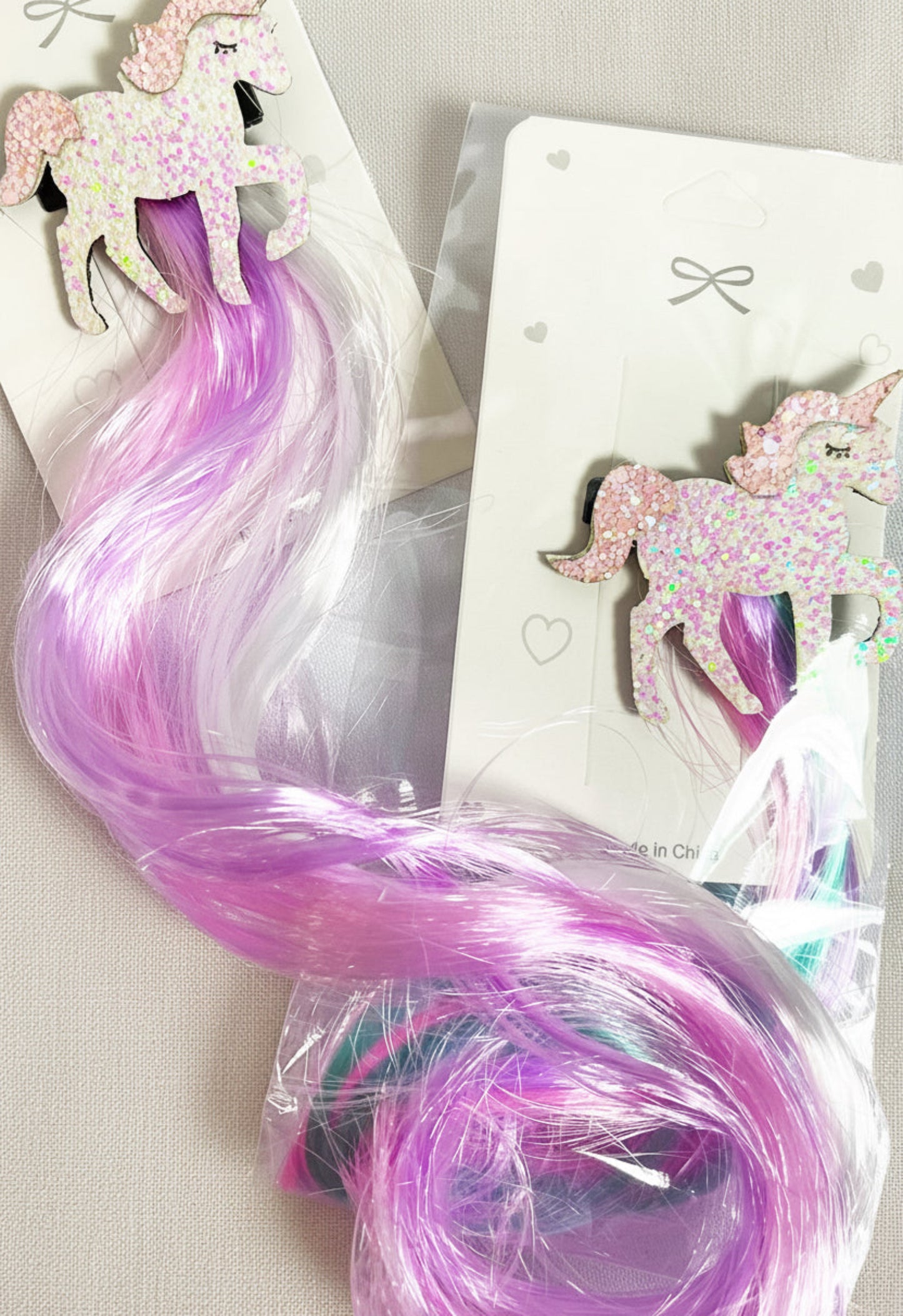A packaged unicorn hair bow with fake hair extending out,.