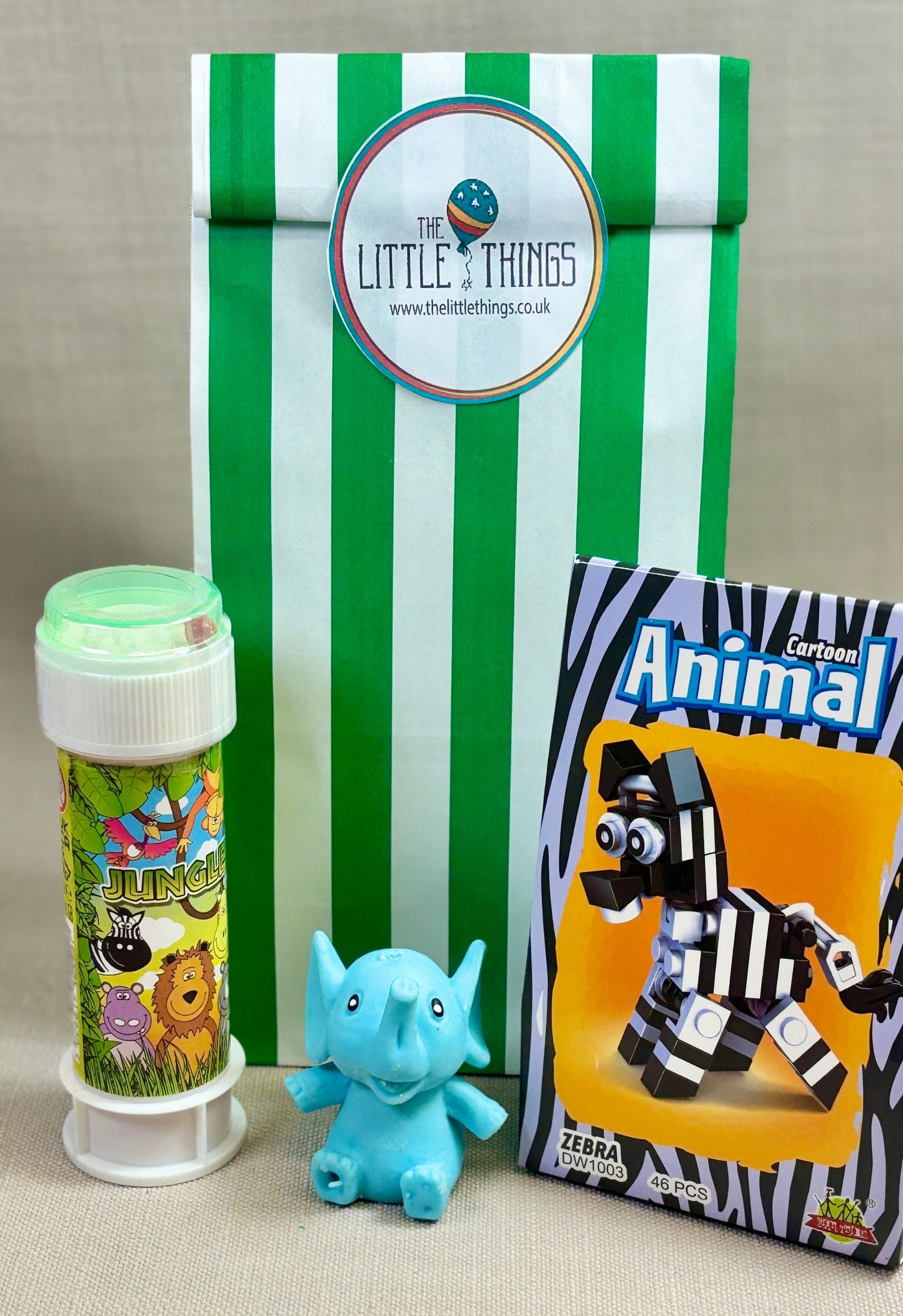 Animal bricks, green and white striped paper party bag, and colourful tube of bubbles. Small Sand animal toy