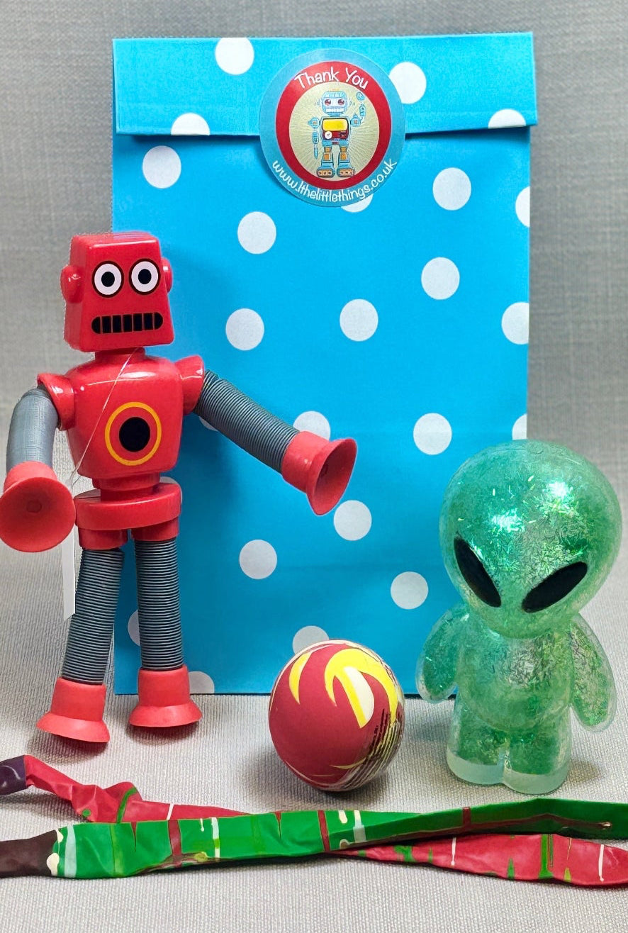 Blue spotty paper party bag with a robot sticker to sea. Bag includes a Stretch arm and leg toy robot, green squishy alien figure, and colourful rocket balloons. 