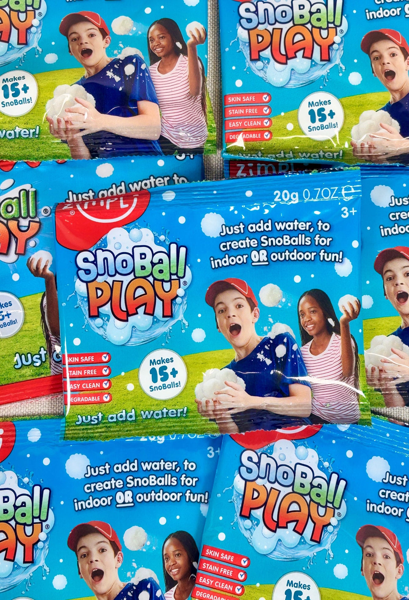 Multiple packages of Zimpli Kids SnoBall Play product with children playing.