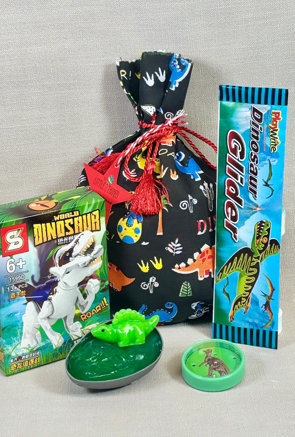 Dinosaur-themed toys and packaging on a gray background