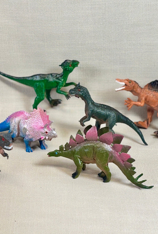 Collection of toy dinosaurs on a light fabric background