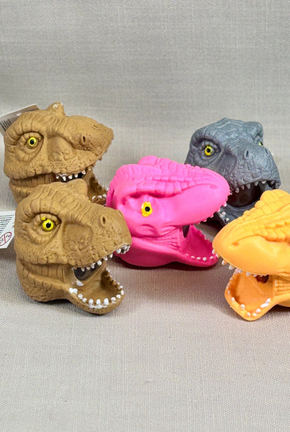Four dinosaur-shaped toys on a gray background