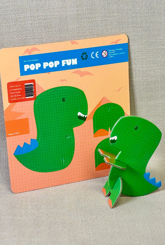 Green dinosaur toy with packaging on a gray background
