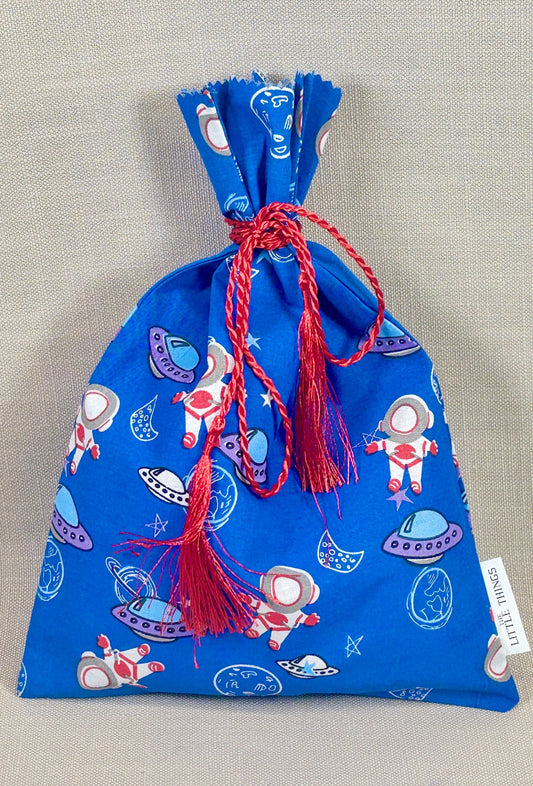 Blue drawstring bag with space-themed design on a gray background