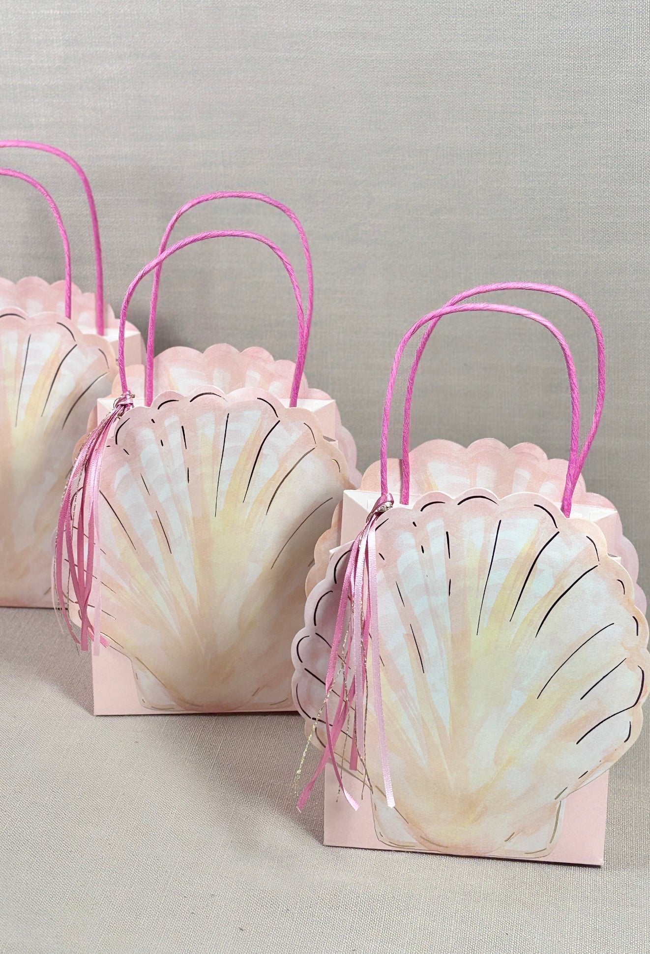 Shell-shaped gift bags with pink handles 