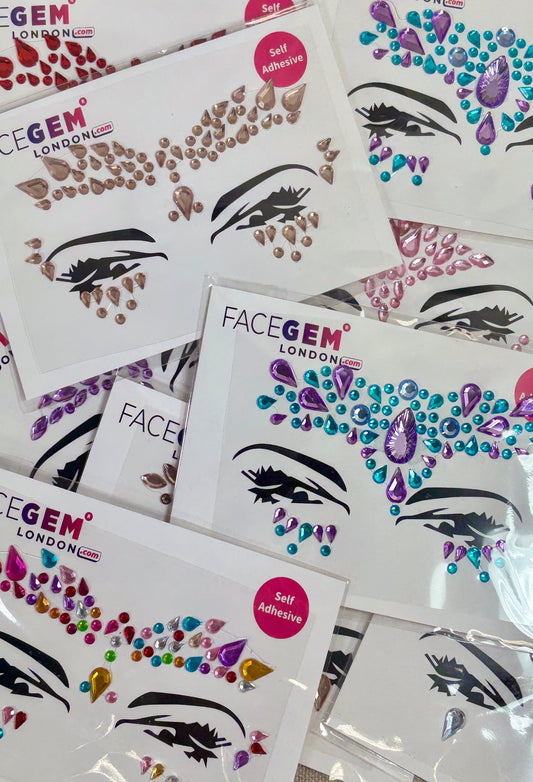 Collection of FaceGem London face decal sheets on a textured surface