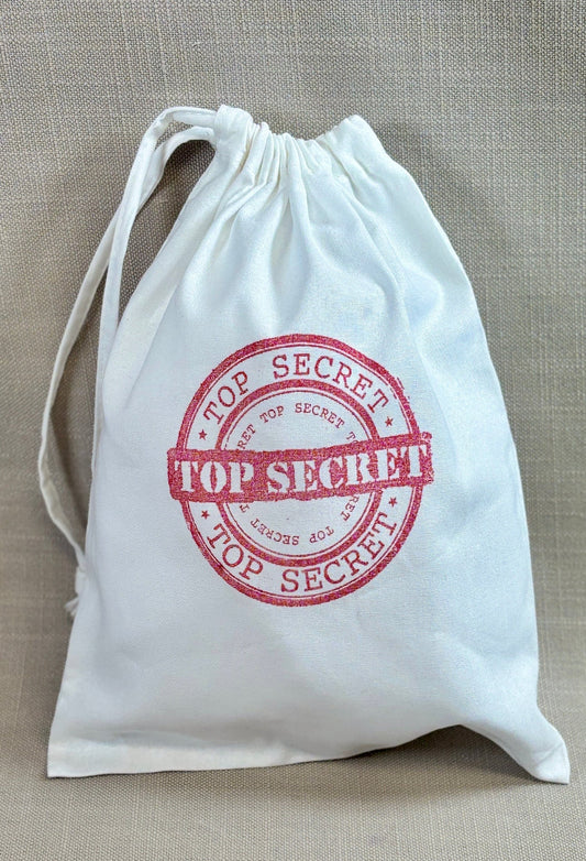 White drawstring party bag with 'Top Secret' stamp. 