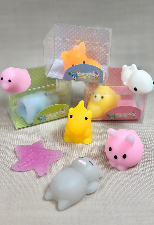 Set of small silicone toys in packaging on a neutral background